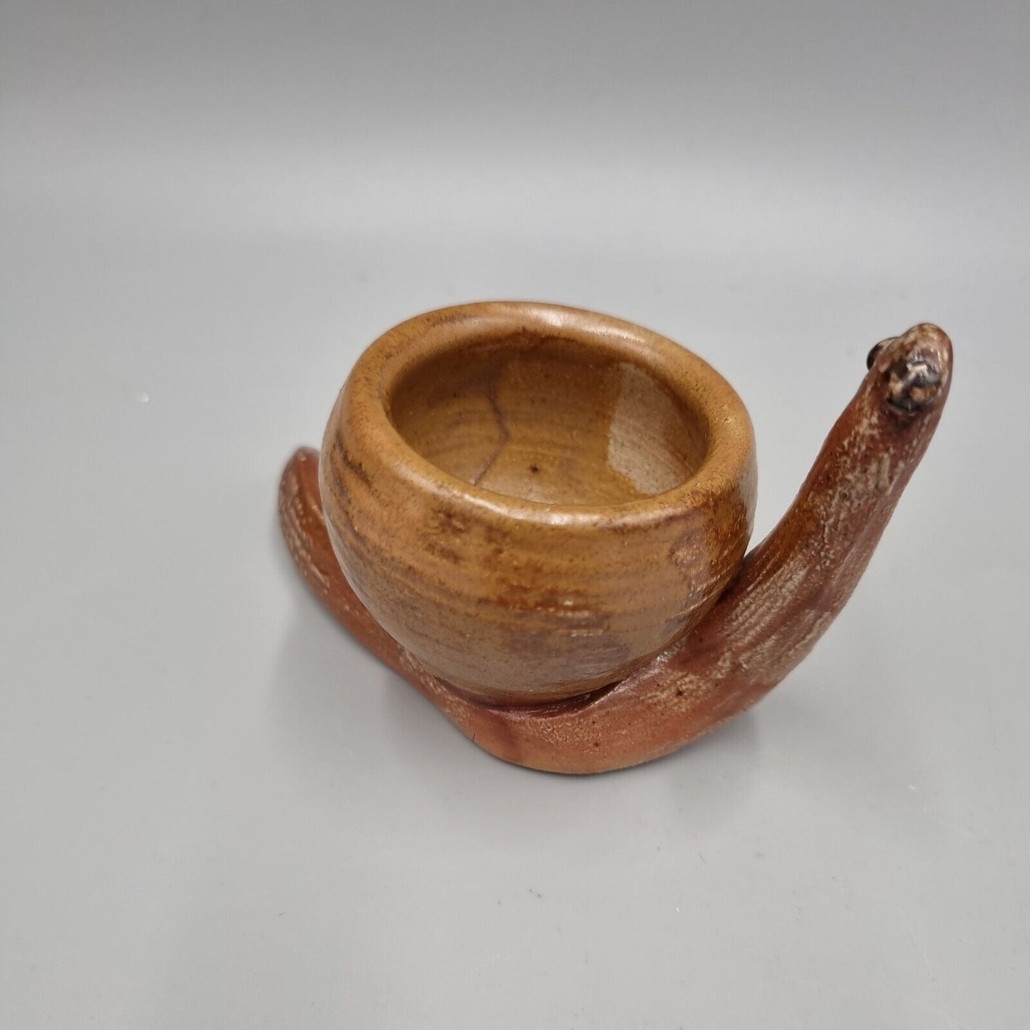 A Rowena Kinsman Studio Pottery 'Snail' Egg Cup Holder.