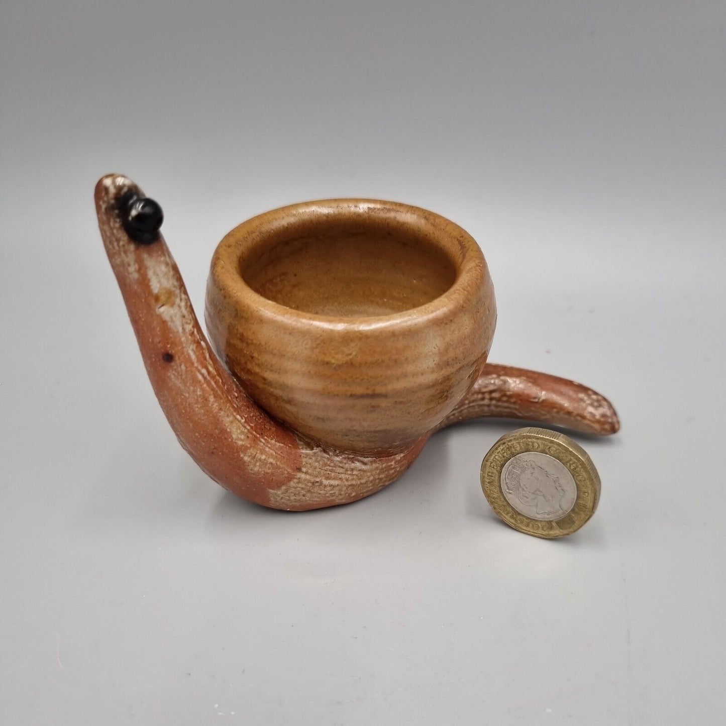 A Rowena Kinsman Studio Pottery 'Snail' Egg Cup Holder.