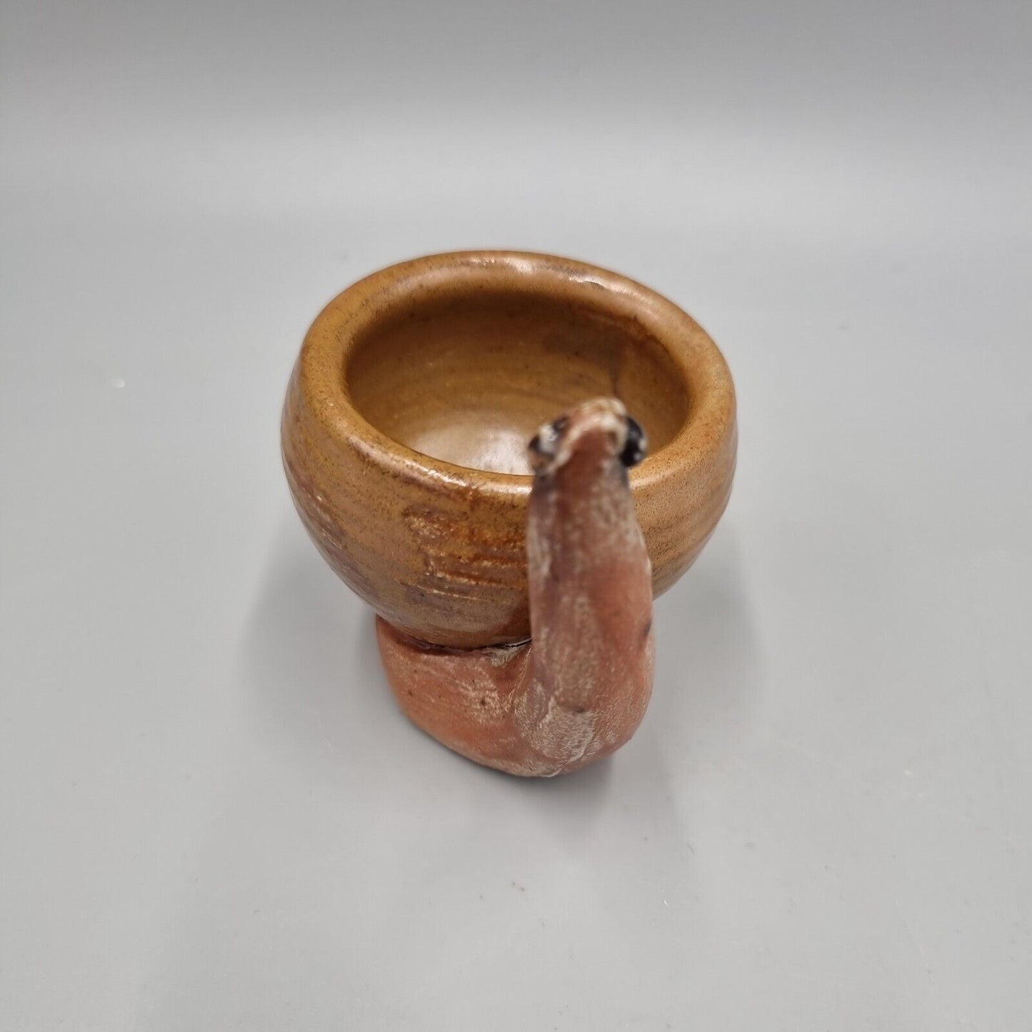 A Rowena Kinsman Studio Pottery 'Snail' Egg Cup Holder.