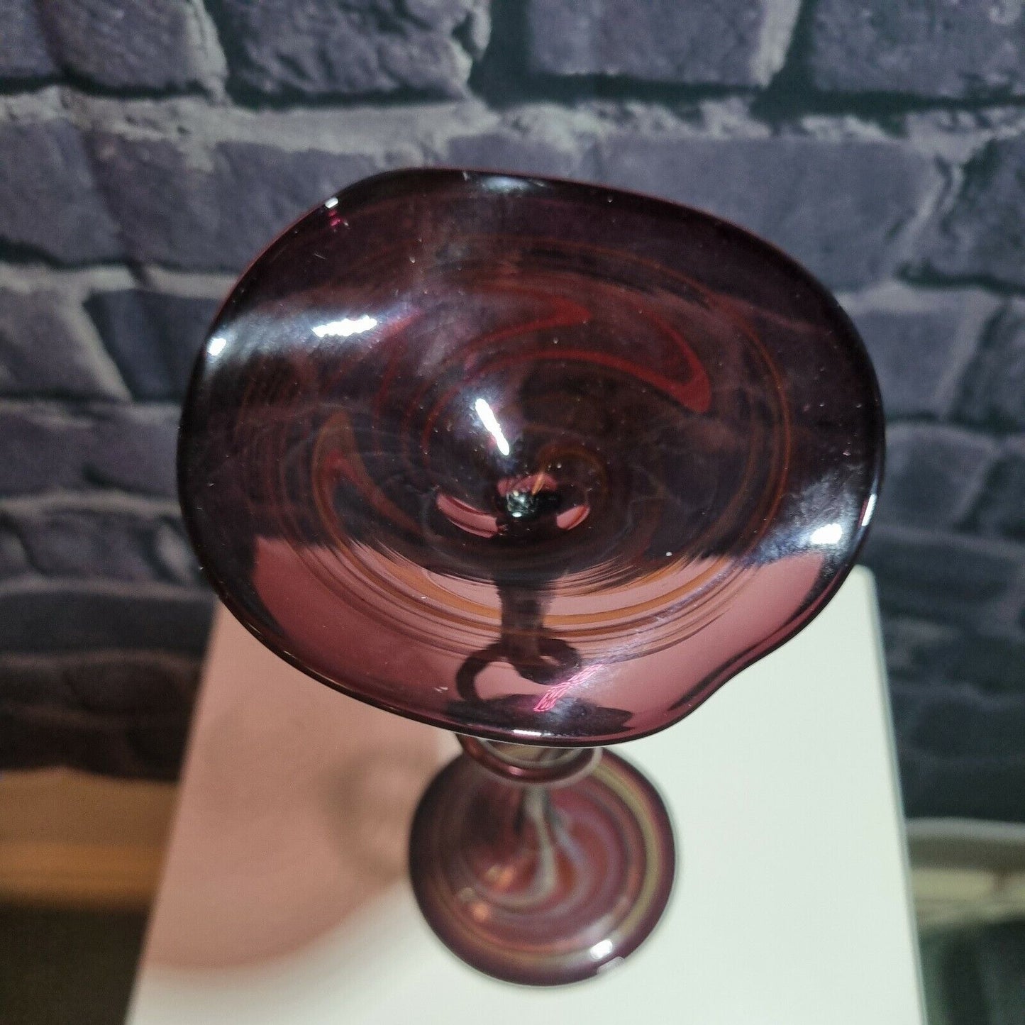 A single twisted stem art glass studio pedestal in deep purple / Amethyst.