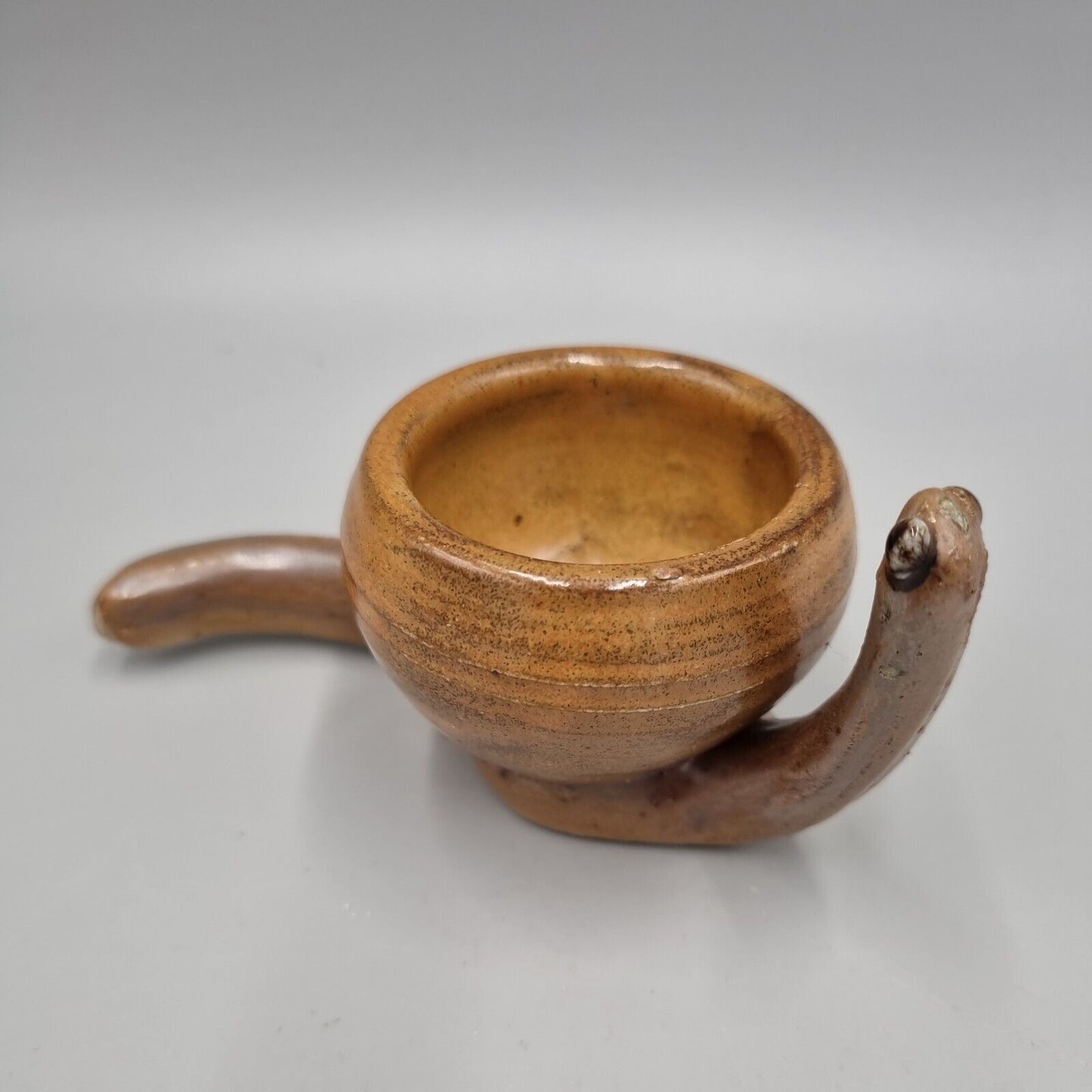 A Rowena Kinsman Studio Pottery 'Snail' Egg Cup Holder.